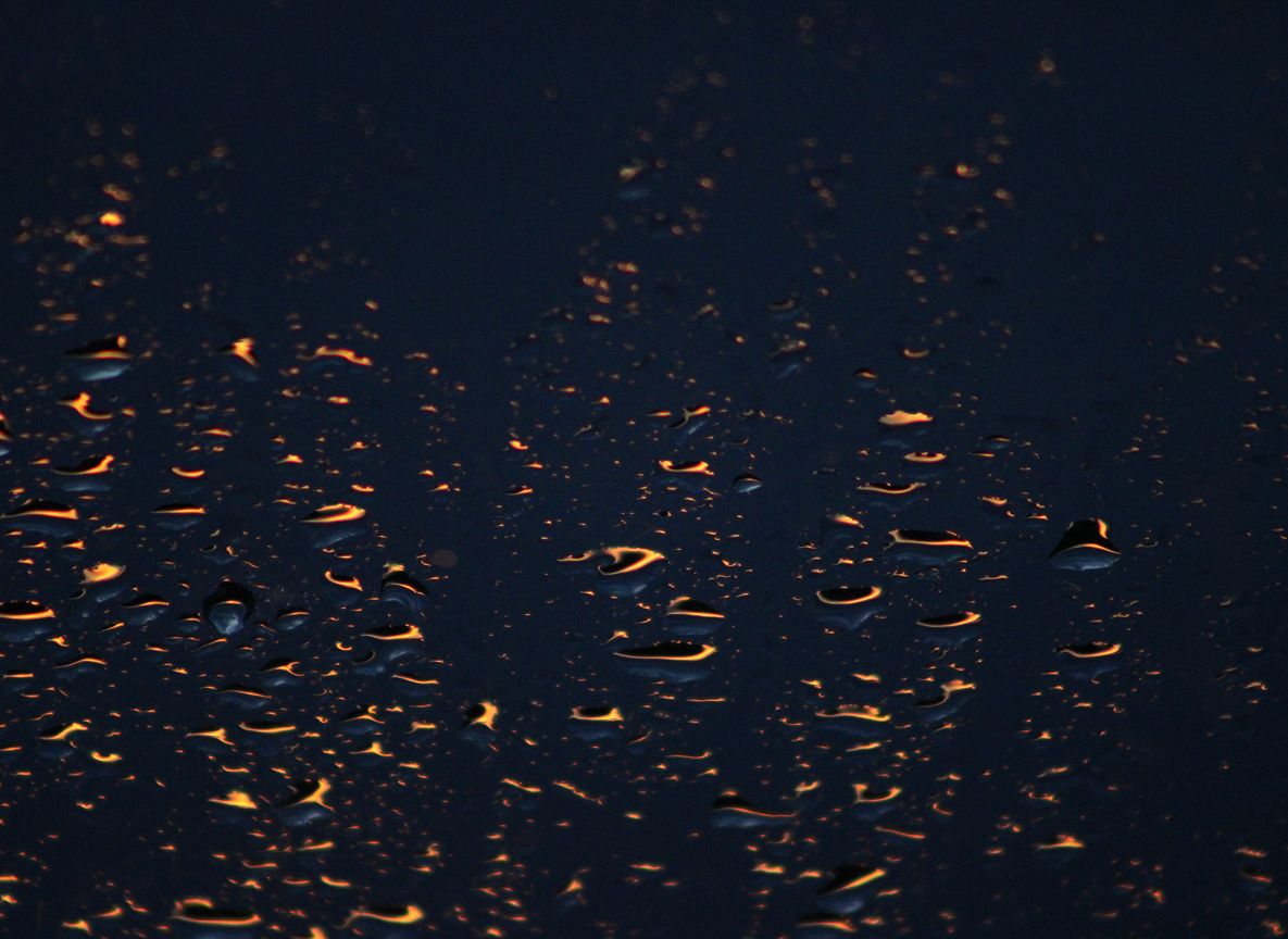 angeleuchteter Regen auf einem Fenster